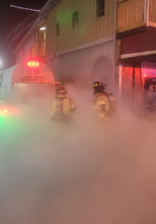 firefighters battling fire surrounded by smoke