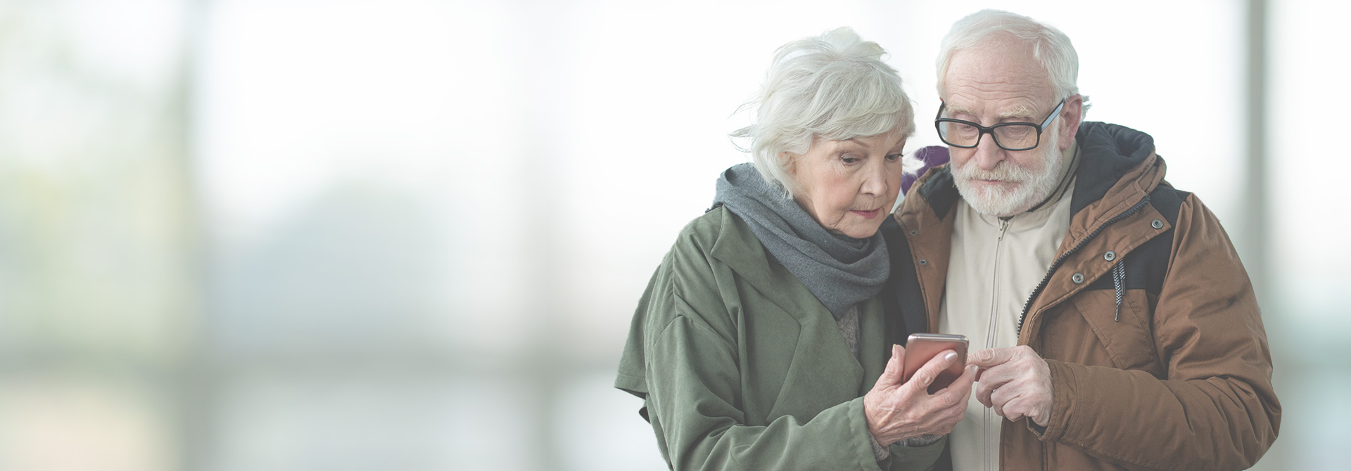 elderly couple looking at phone